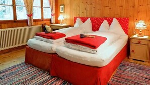 A wooden room with two beds, a radiator, and a window with curtains. - Berg Hütte Hochpillberg by Interhome (Pill)