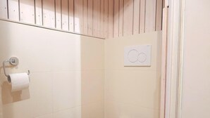 A small, white bathroom with a toilet, a toilet paper holder, and a wall-mounted flush handle. - Berg Hütte Hochpillberg by Interhome (Pill)