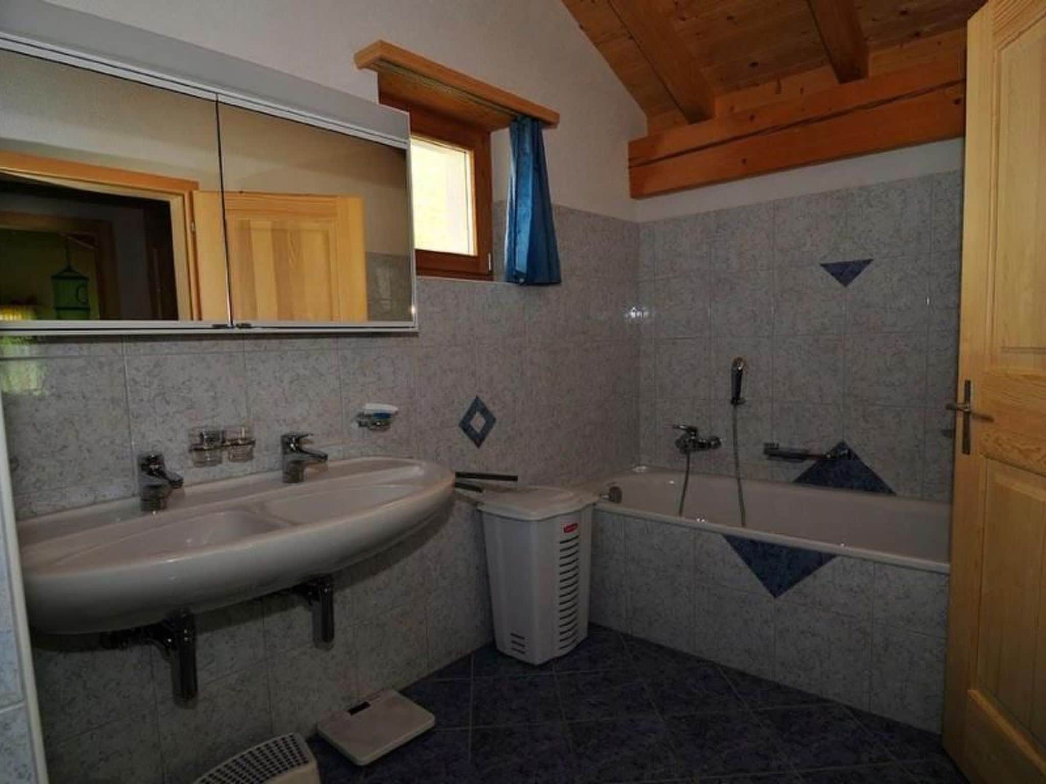 Une salle de bain avec un lavabo, un miroir, une douche et un plafond en bois.