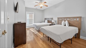 A bedroom with two single beds, a ceiling fan, a wooden dresser, and a window. - World Tour 1009-302 (Myrtle Beach)