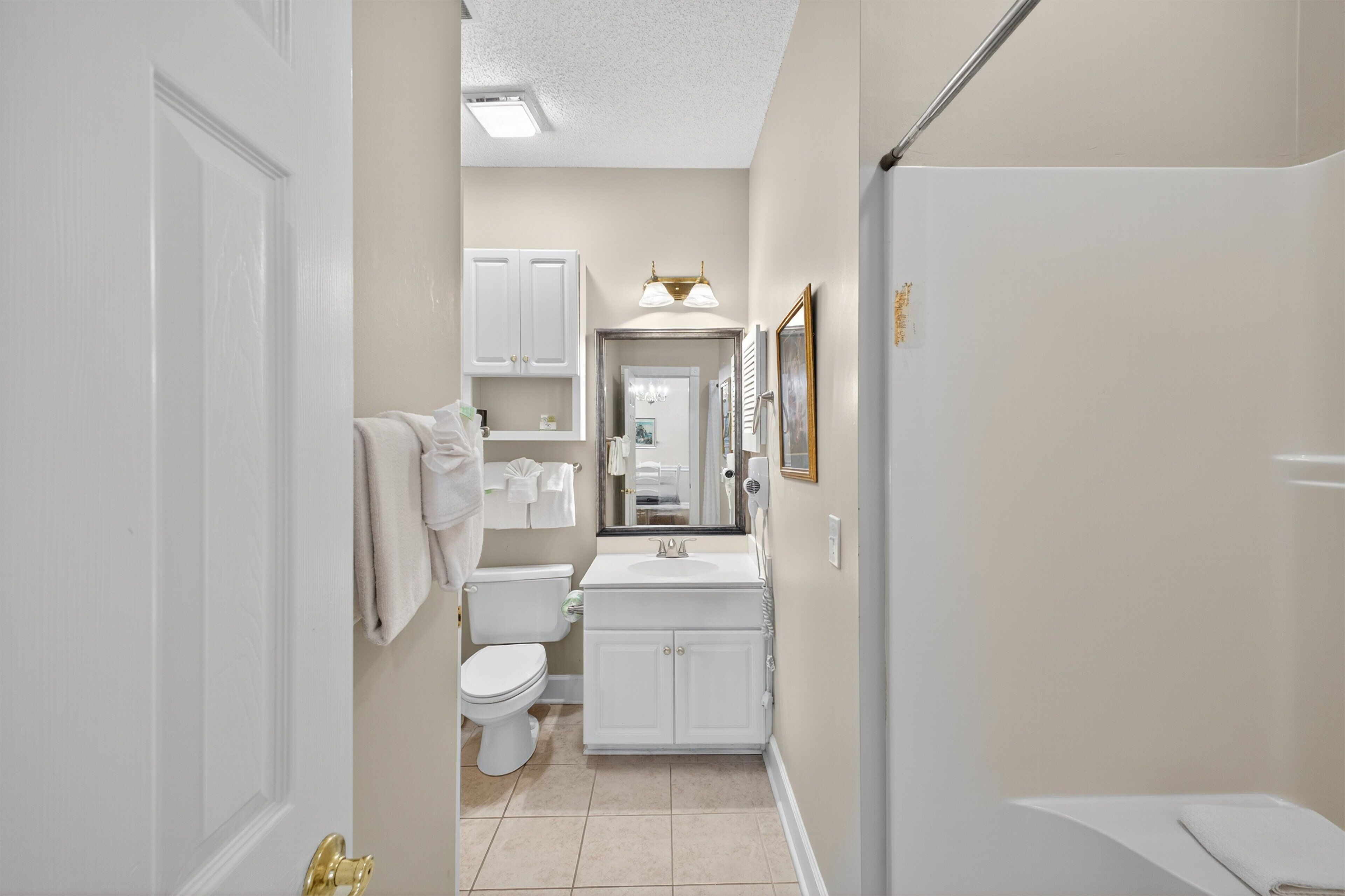 A bathroom with a toilet, sink, and shower.