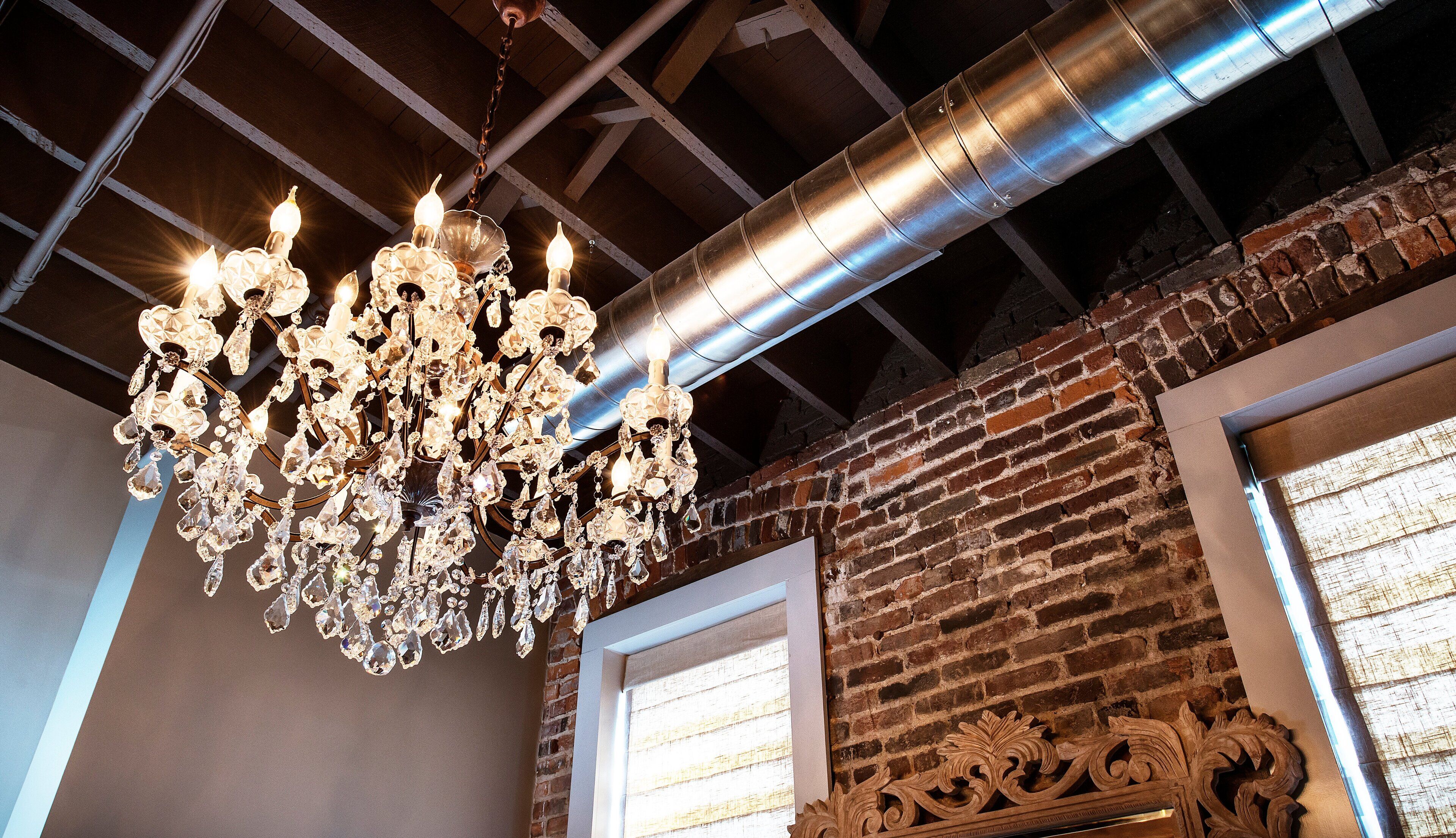 Un lustre orné de nombreuses ampoules et de décorations en cristal, suspendu au plafond.