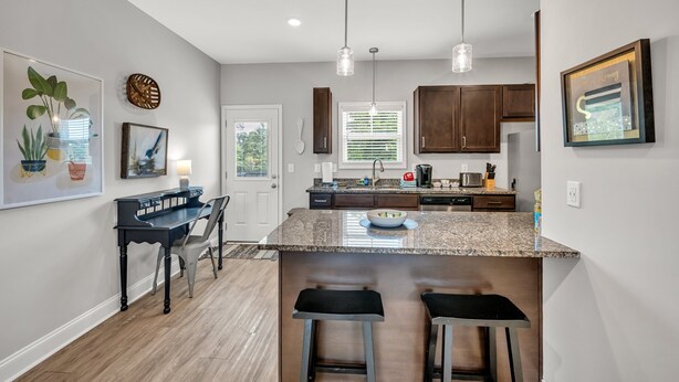 A modern kitchen with granite countertops, wooden cabinets, and pendant lighting. - Tee Time Treasures in Sango 1625 Gold Club Ln, #602 (Nashville)