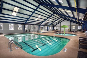 An indoor swimming pool with clear lanes, a covered roof, and lounge areas. - Magnolia Place 4757-104 (Myrtle Beach)