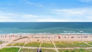 A beach with umbrellas and people, a clear sky, and the ocean. - Meridian Plaza 1401 (Myrtle Beach)