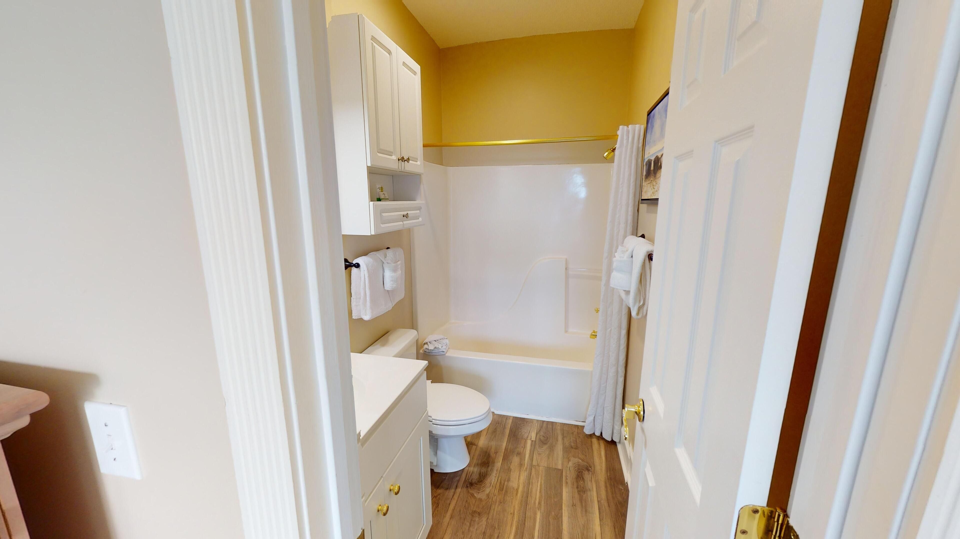 Une petite salle de bain comprenant des toilettes, un lavabo et une baignoire.
