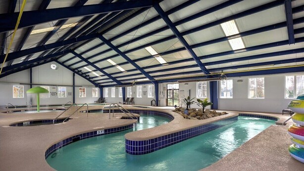 Ein haubtdeckendes Schwimmbad mit geschwungenem Design, mehreren Bahnen und einer Fliesenbordatur.