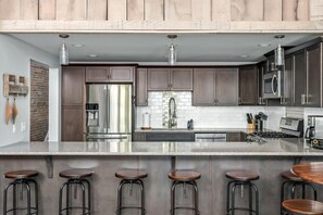 A modern kitchen with dark wood cabinets, stainless steel appliances, and a granite countertop. - Bettye - A (Nashville)