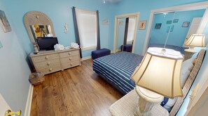 Une chambre à coucher avec un lit, une commode et un miroir.