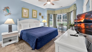 A bedroom with a bed, nightstands, a ceiling fan, a TV, and a window with curtains. - Magnolia Pointe Luster Leaf 4882-104 (Myrtle Beach)