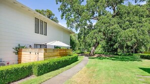 Une maison de plain-pied dotée d’un patio couvert, d’un chemin piétonnier dallé et d’une pelouse bien entretenue.