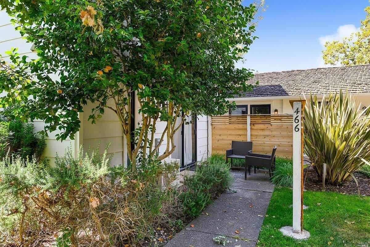 Ein Haus mit der Hausnummer 46, einem Holzzaun und einem Garten mit verschiedenen Pflanzen.