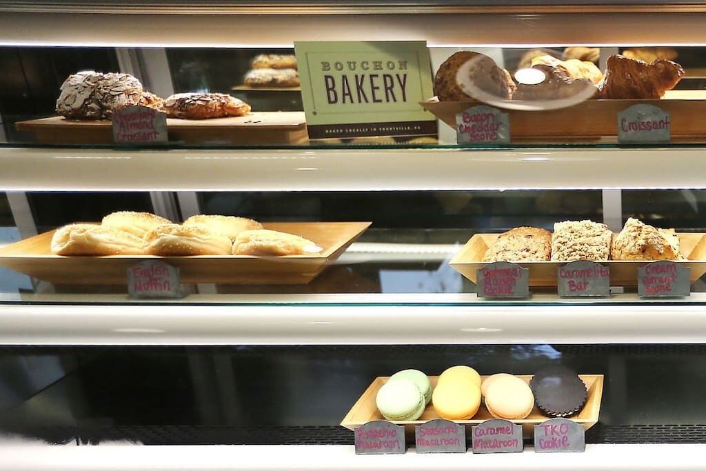 A bakery display with various baked goods and labels indicating different types of pastries.