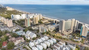 Ein Luftbild einer Küstenstadt mit Hochhäusern, einem Strand und einer Mischung aus Wohn- und Geschäftsgebäuden.