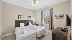 A hotel room with two beds, a ceiling fan, a TV, and a window with curtains. - Magnolia Place 4639-103 (Myrtle Beach)