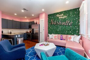 A modern kitchen with dark cabinets, a stainless steel refrigerator, and a countertop. - Pink Party Nashville-near Music Row, Free Parking (Nashville)