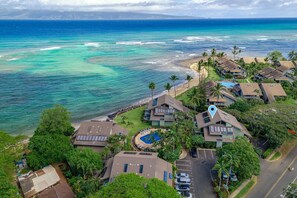 A coastal resort with multiple bungalow-style buildings, a swimming pool, and a beach. - Kahana Outrigger 4B1 (Napili-Honokowai)