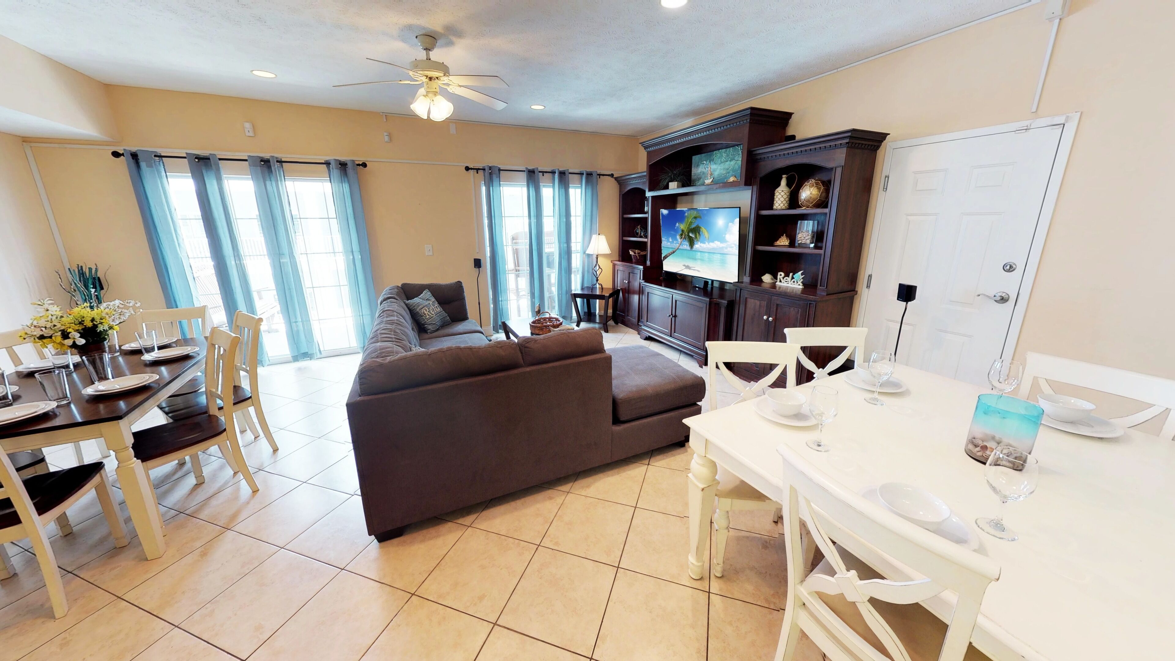 A well-lit living room with a sofa, dining table, and TV.