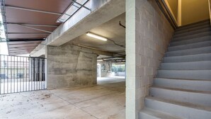 A multi-level parking garage with concrete pillars, a staircase, and a metal fence. - The Celebrity - Free Parking, Central, Vanderbilt (Nashville)
