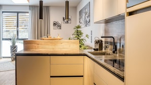 A modern kitchen with a wooden island, pendant lights, and a built-in stove.