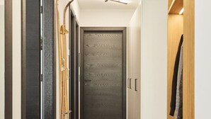 A hallway with a wooden wardrobe, a black door, and a coat rack. - Stillvolle Luxus Wohnung in der Residenz Silvretta by Interhome (See)