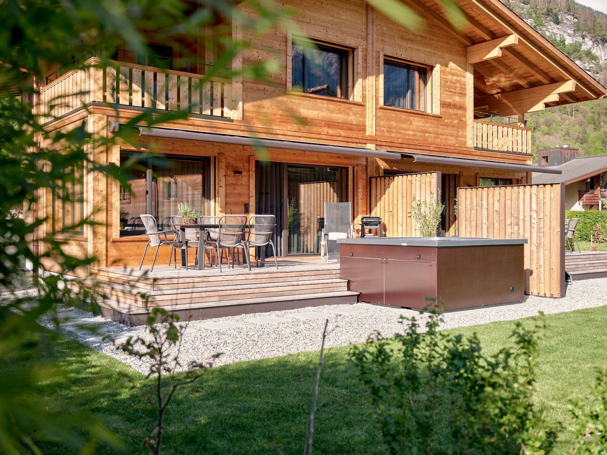 Une cabane en bois dotée d’une terrasse, d’un espace salon extérieur et d’un coin barbecue.