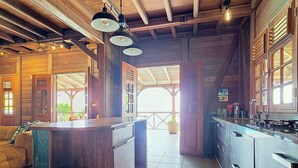 Una cocina amplia con armarios de madera, una isla central y un gran ventanal que proporciona luz natural.