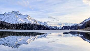 A tranquil lake reflecting snow-capped mountains under a clear sky.