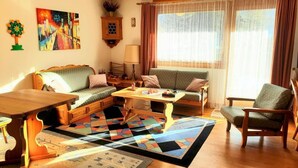 Un salon confortable avec un canapé, des fauteuils, une table basse et un tapis.