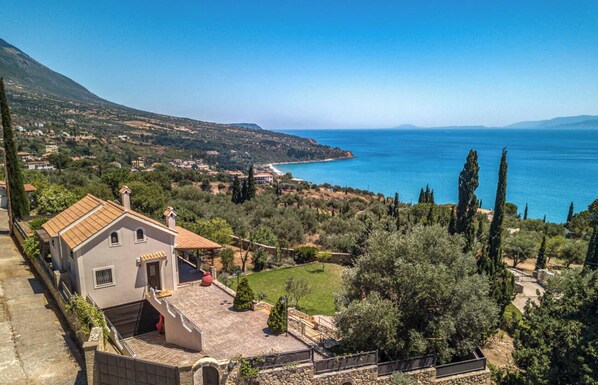 A coastal property with a house overlooking the sea, a garden, and a view of the coastline. - Villa Harmony with jacuzzi, in Lourdata of Kefalonia. (Lourdata)