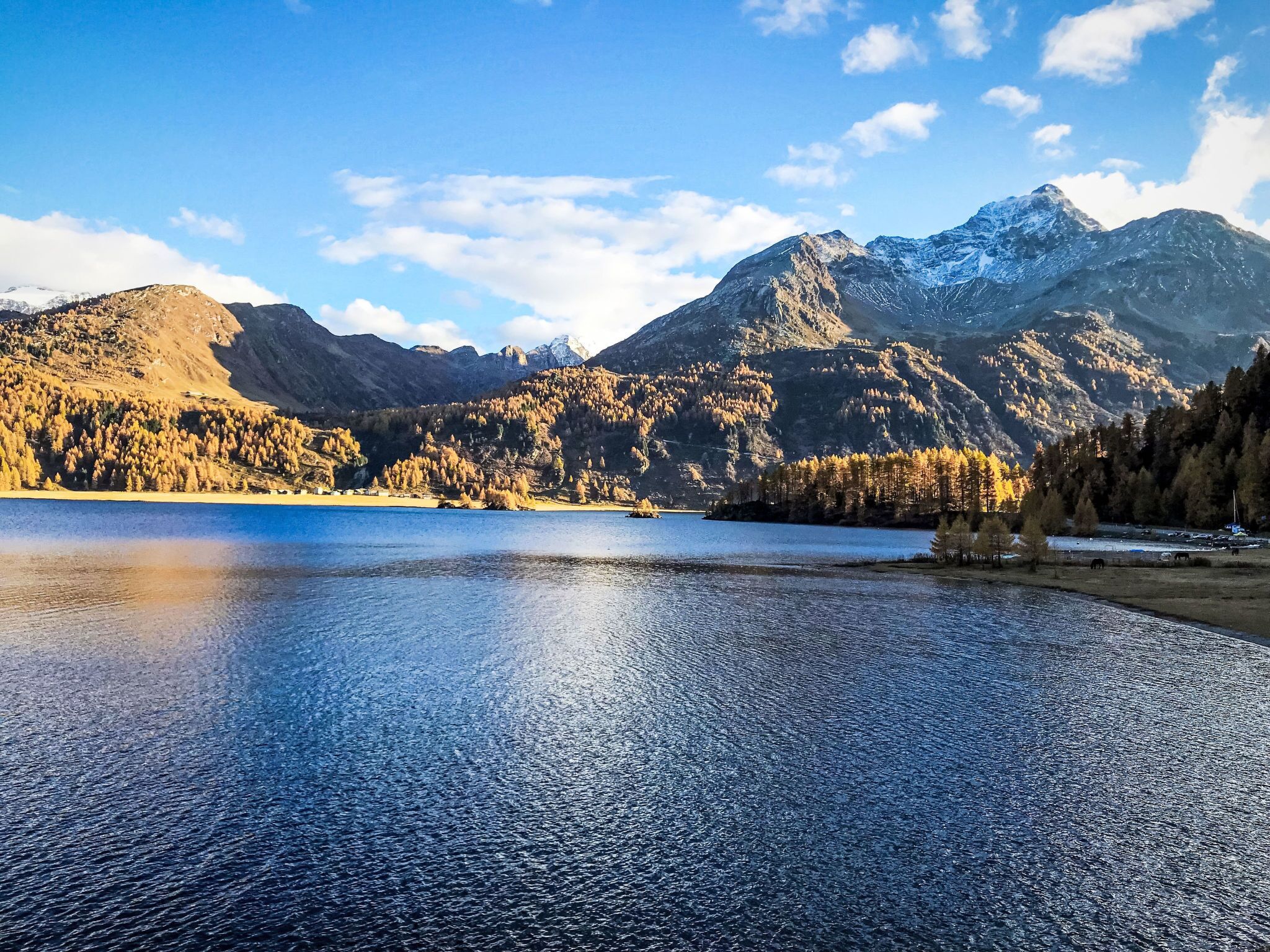 Un lago sereno rodeado de montañas y árboles.