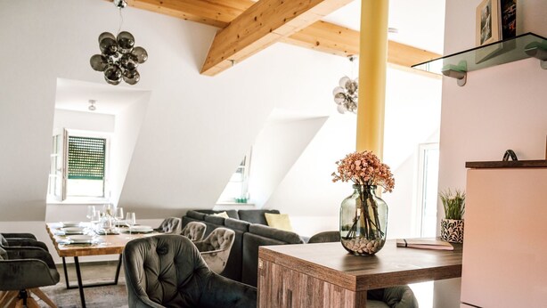 Un espace de vie moderne de style loft comprenant un coin repas, une cuisine et un coin salon.