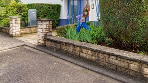 A two-story residential building with a blue door, a small balcony, and a well-maintained garden. - ApartmentmitAusblick by Interhome (Wörth)