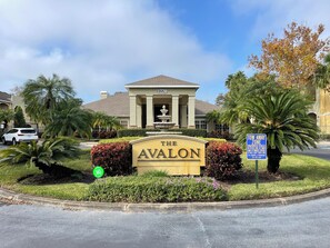 Schild für "The Avalon" mit befestigtem Eingang, einem Brunnen und einem Schild "Abschleppbereich".