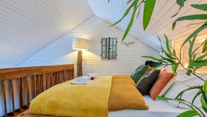 A cozy bedroom with a wooden bed, a bedside lamp, and a window with shutters. - Schwarzwald Loft mit Schwimmbad und herrlicher Aussicht by Interhome (Sasbachwalden)