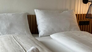 A hotel room with two beds, white linens, and a wooden headboard. - für 3 Personen  + 1 Kind ca. 38 m² in Zell am See, Österreichische Alpen ( by Interhome (Zell am See)