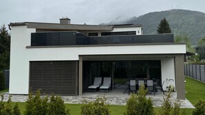 A modern two-story house with a covered patio area and a garage. - für 3 Personen  + 1 Kind ca. 38 m² in Zell am See, Österreichische Alpen ( by Interhome (Zell am See)