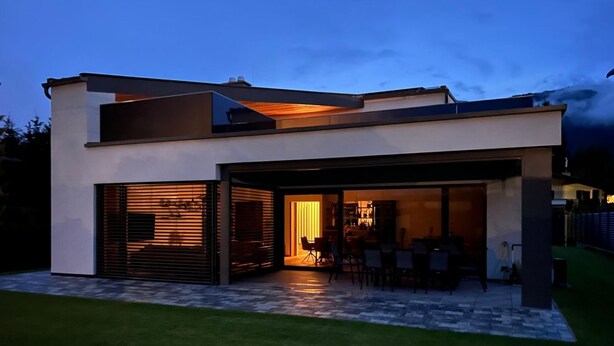 A modern house with a covered patio, a visible kitchen area, and a well-maintained lawn. - für 3 Personen  + 1 Kind ca. 38 m² in Zell am See, Österreichische Alpen ( by Interhome (Zell am See)