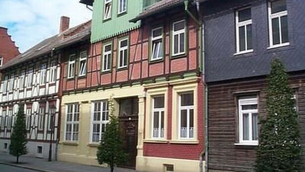 A row of traditional half-timbered houses with distinct architectural styles and colors. - Gemütliche Wohnung in Wernigerode mit Garten by Interhome (Wernigerode)
