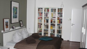 A bedroom with a bed, a bookshelf, and a door. - Gemütliche Wohnung in Wernigerode mit Garten by Interhome (Wernigerode)
