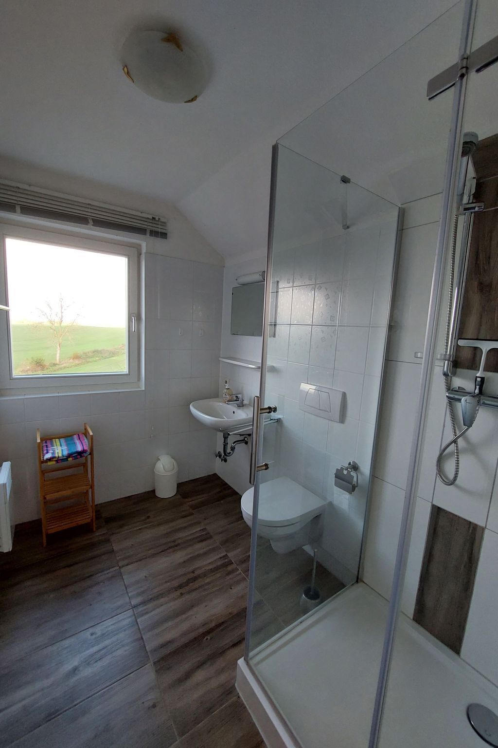 Un baño moderno con cabina de ducha de vidrio, lavamanos y retrete.