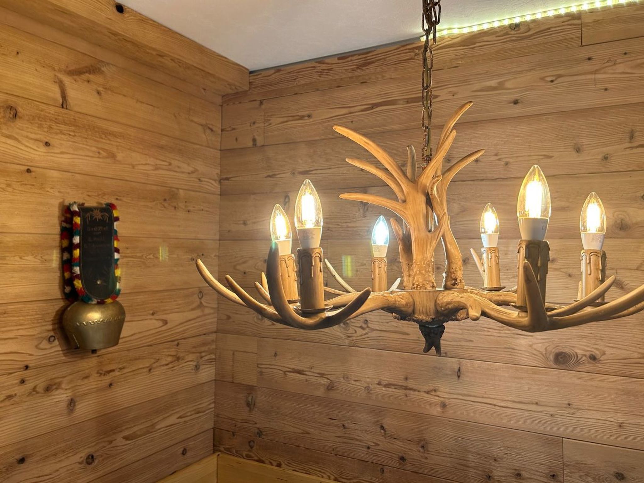 Un interno in legno con un lampadario dotato di numerose luci.