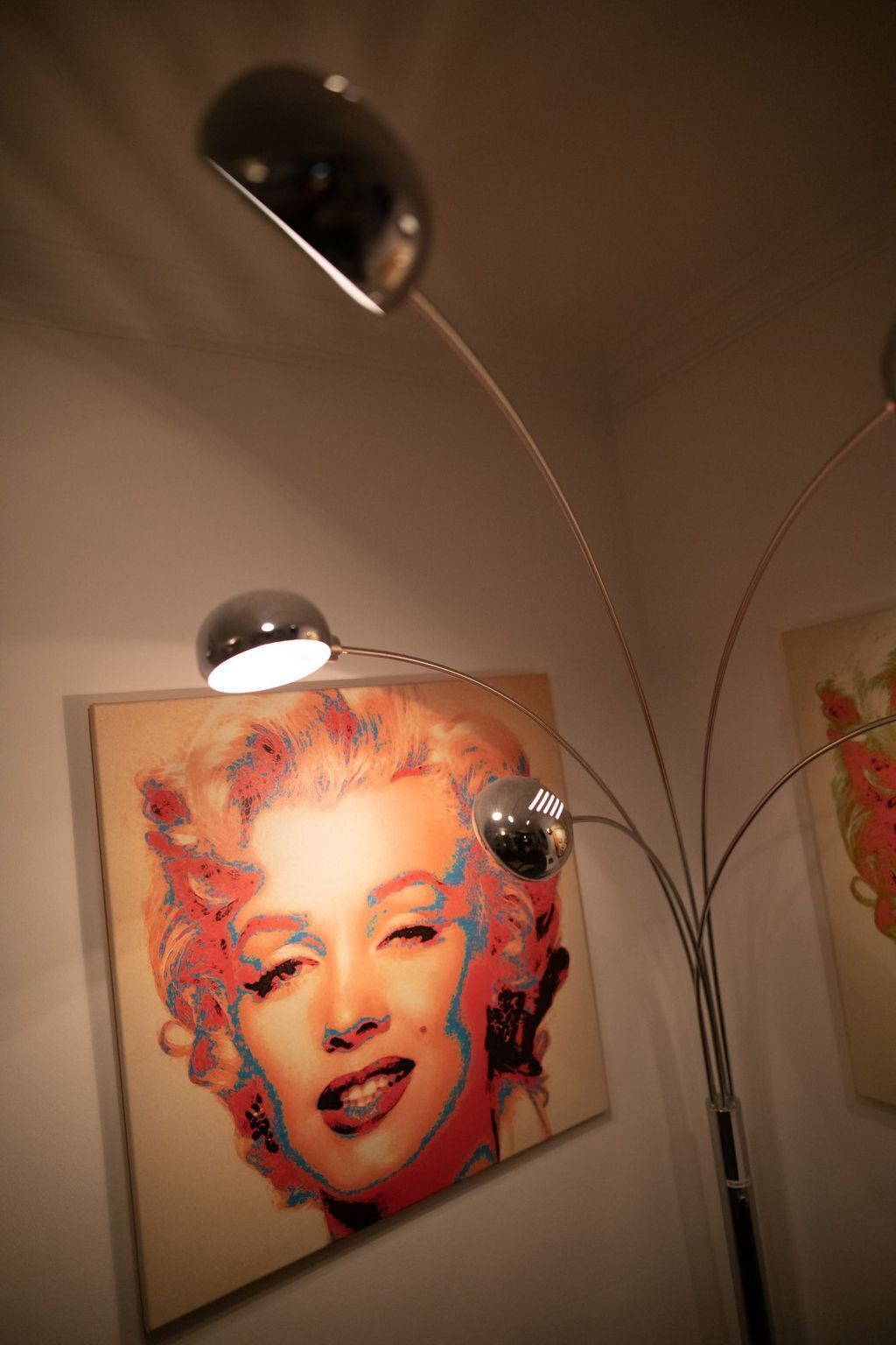 Une œuvre d’art encadrée, éclairée par un projecteur situé au-dessus.