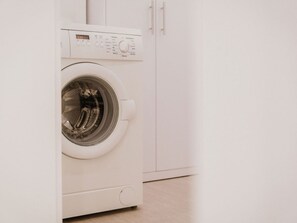 A front view of a white washing machine in a room with white cabinets. - am Weinberg by Interhome (Bötzingen)