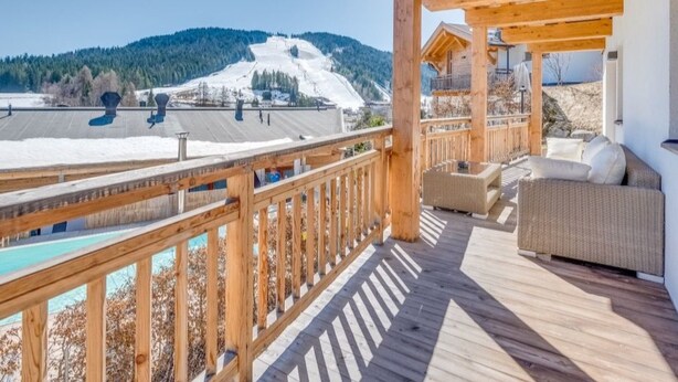 A wooden deck with a view of a snowy mountain and a ski slope. - Luxus Chalet Poolblick - mit eigener Sauna by Interhome (Seefeld in Tirol)