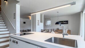 A modern kitchen with a central island, stainless steel sink, and a built-in oven. - Luxus Chalet Poolblick - mit eigener Sauna by Interhome (Seefeld in Tirol)