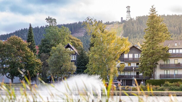 Un quartier résidentiel avec des maisons, un plan d’eau et une fontaine.