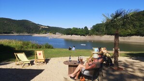 A lakeside setting with beach chairs and a table, surrounded by greenery and a clear view of the lake. - für 6 Personen ca. 60 m² in Diemelsee-Heringhausen, Hessen (Hessisches Ber by Interhome (Diemelsee)