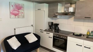 A compact kitchen with a black sofa, a coffee maker, and a kettle. - Appartement Wasserfall by Interhome (Stall)