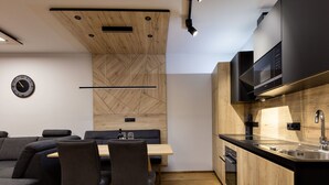 Una cocina moderna con armarios de madera, horno empotrado y microondas negro.